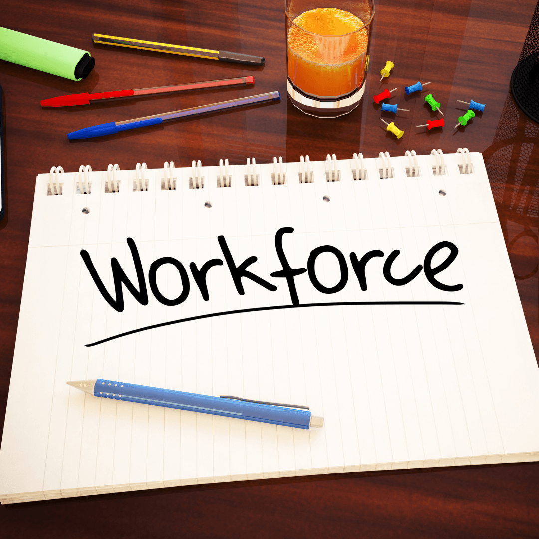 A spiral notebook on a desk with the word Workforce written across it.