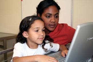 Young girl and teacher at computer