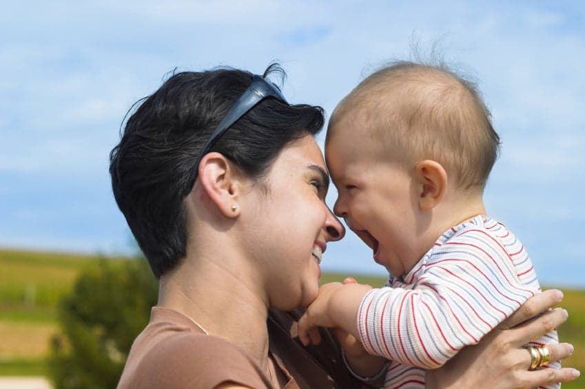 Mother and baby are laughing together.