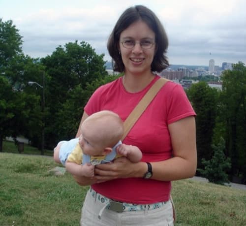 Mother holding infant in an airplane position to support the infant’s digestion