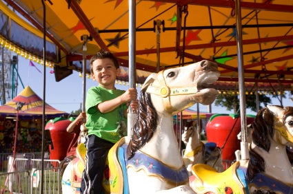 kid riding carousel