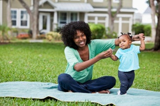 Mother helping baby walk