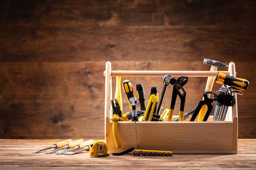 Toolbox With Various Worktools On Wooden Surface